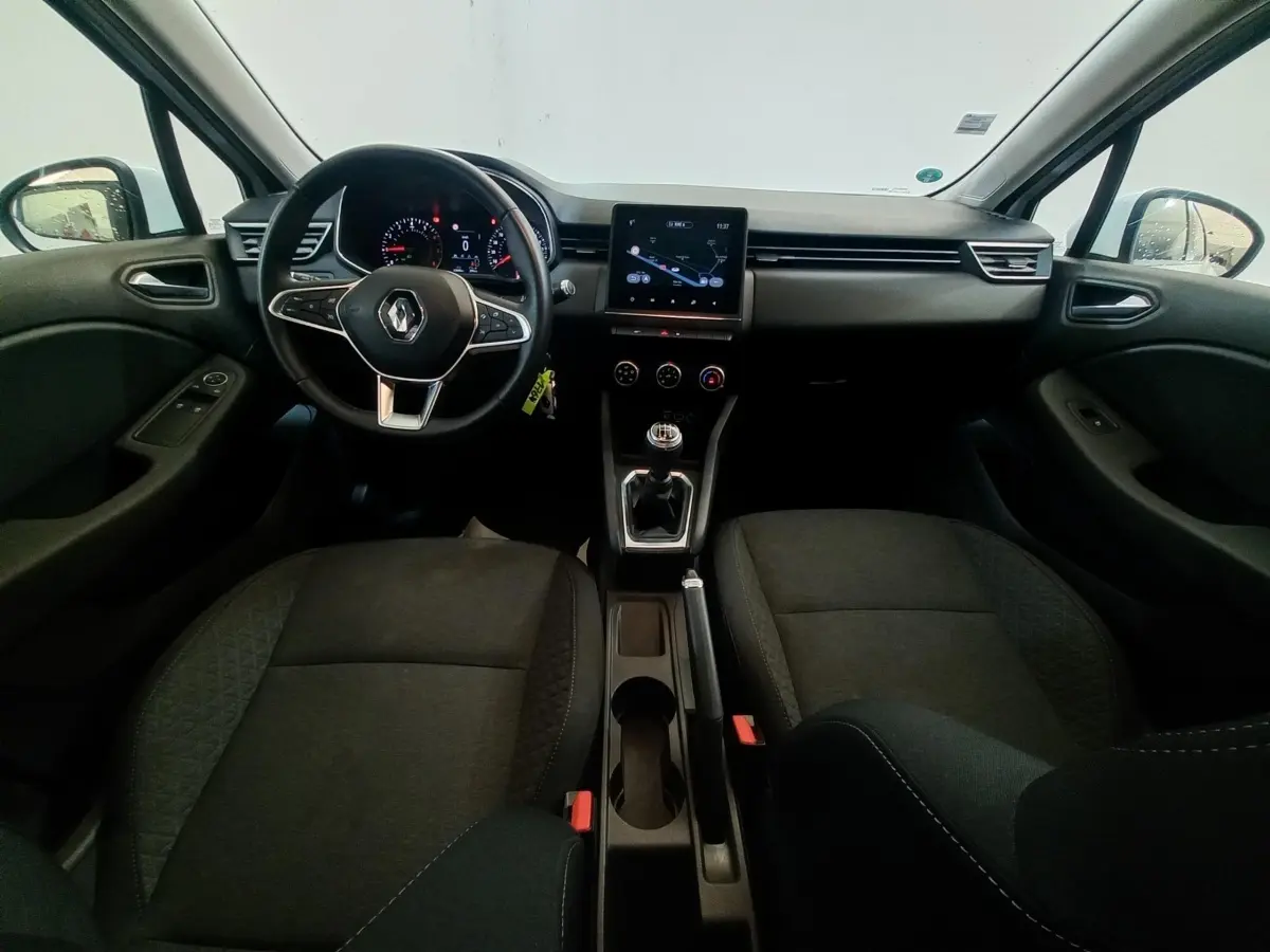 Intérieur avant de la Renault Clio Business blanc, vue centrée sur le tableau de bord, volant multifonctions et écran tactile.
