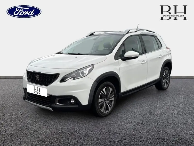 Peugeot 2008 blanc Banquise vue 3/4 avant droit, avec barres de toit et jantes alliage distinctives.