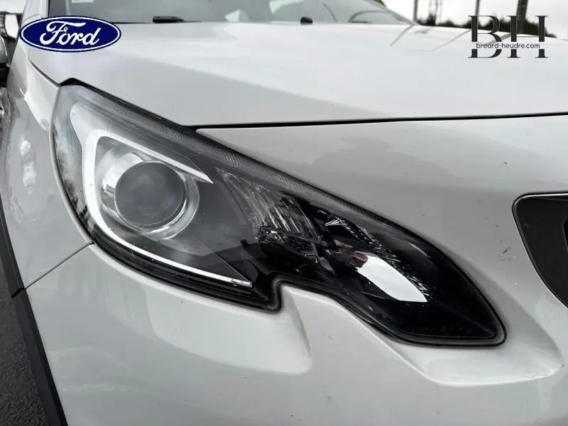 Gros plan sur le phare avant droit blanc Banquise du Peugeot 2008, soulignant son design moderne et précis.