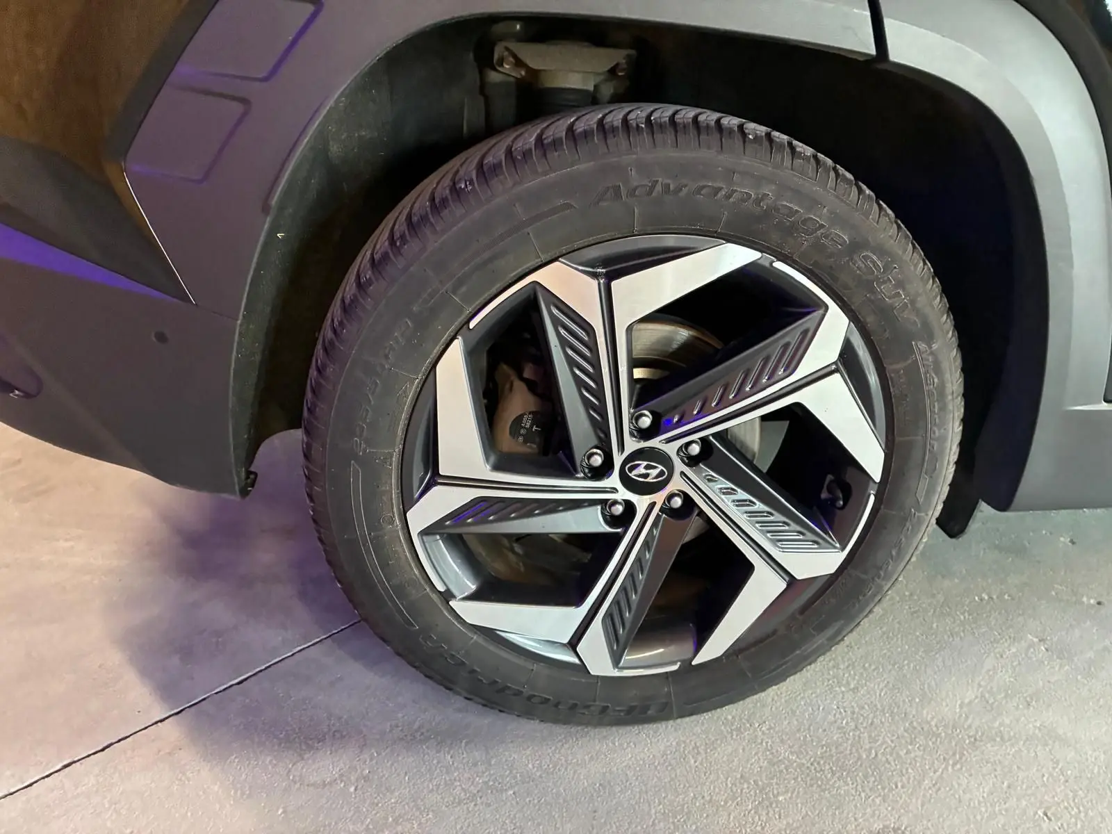 Gros plan sur la roue avant droite du Hyundai Tucson noir 2022 avec jante alliage au design moderne.