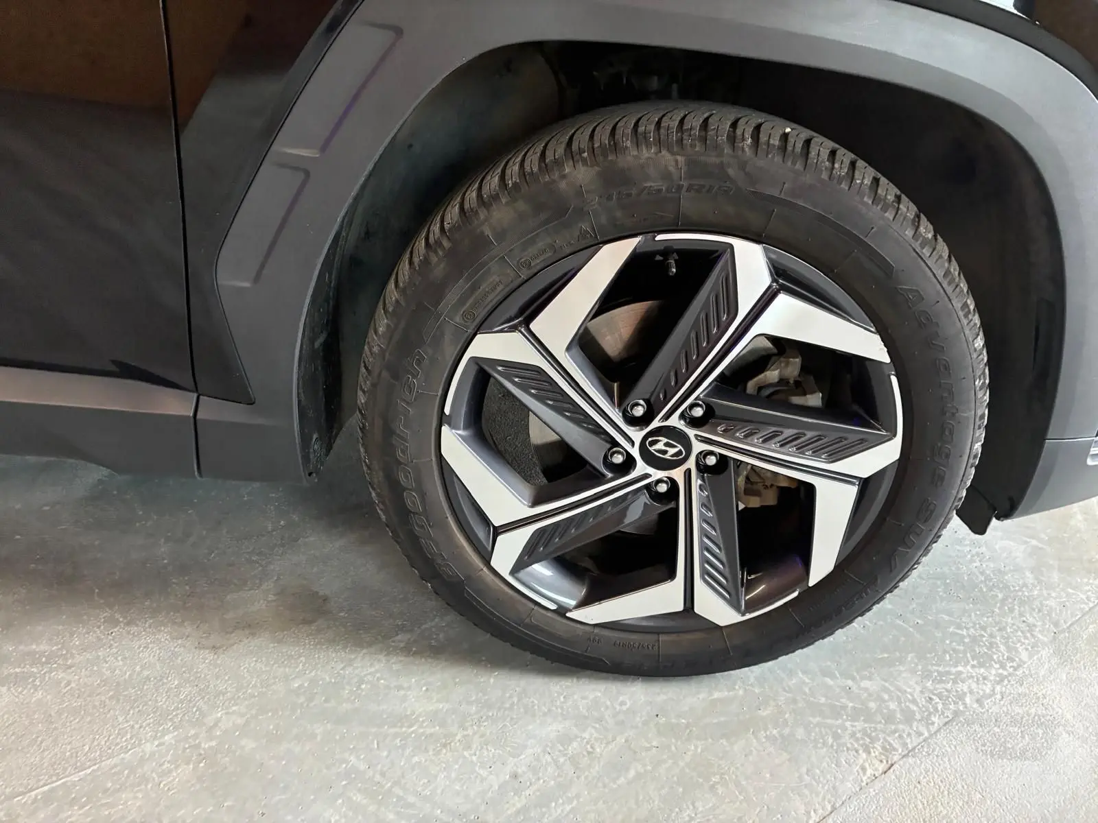 Gros plan sur la roue avant gauche noire d’un Hyundai Tucson 2022, mettant en valeur la jante alliage au design moderne.
