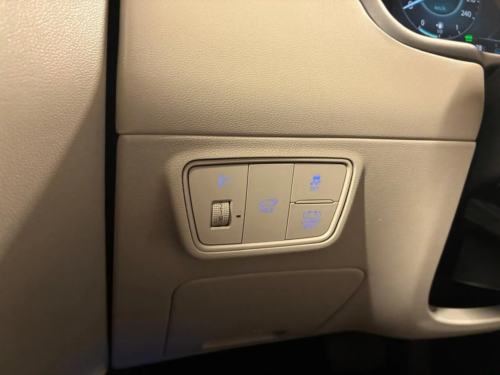 Détail des commandes éclairage et assistances sur panneau beige côté gauche du tableau de bord du Hyundai Tucson noir 2022.