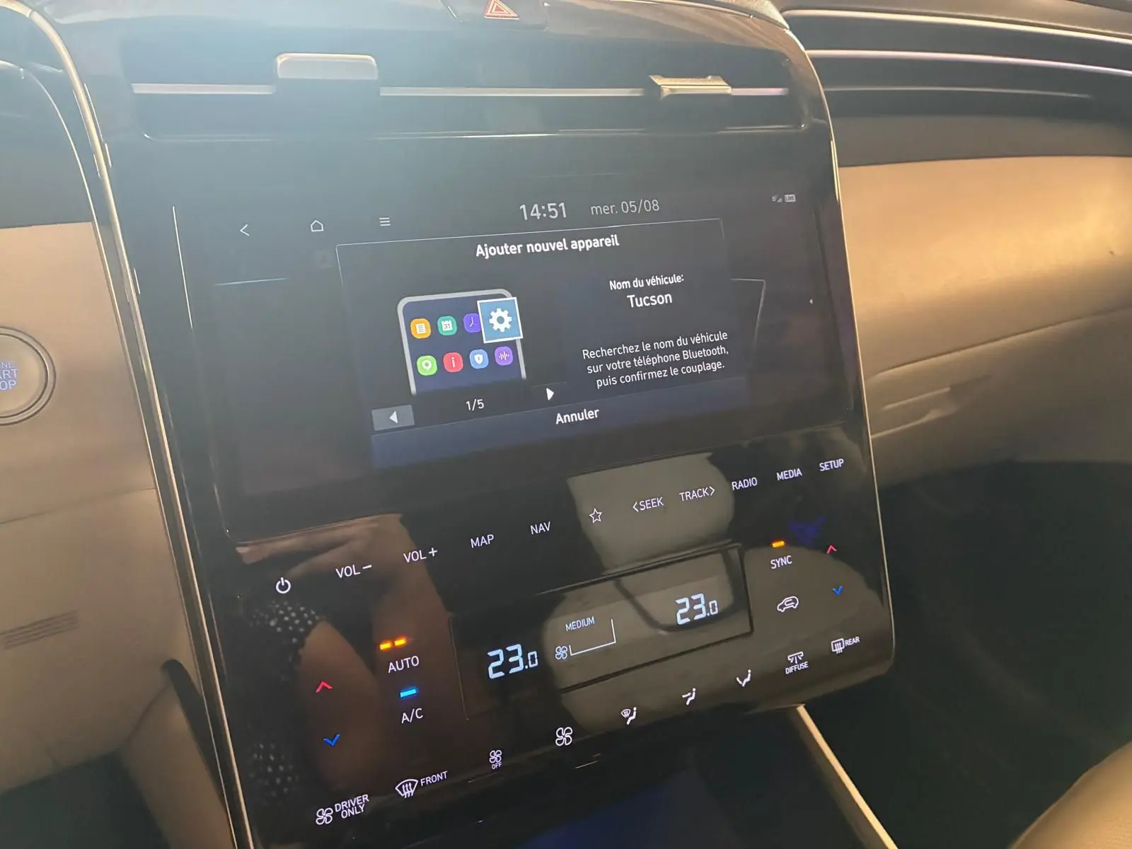 Vue rapprochée de la console centrale tactile du Hyundai Tucson noir 2022, affichant les réglages de climatisation et Bluetooth.