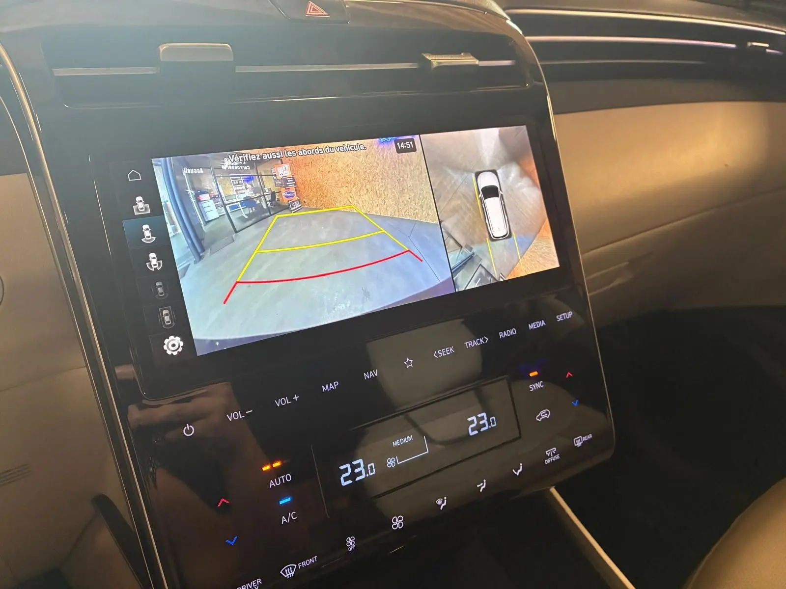 Écran central du Hyundai Tucson 2022 noir montrant la caméra de recul et les commandes de climatisation digitale.