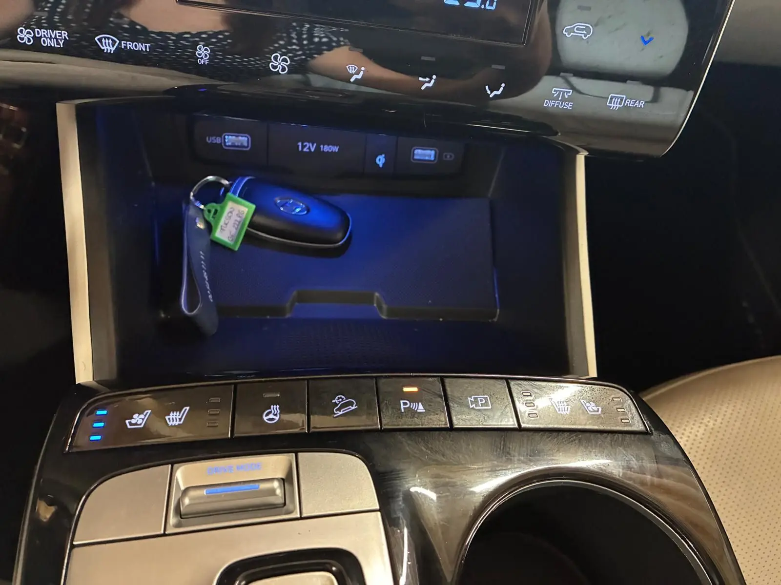 Gros plan sur la console centrale noire du Hyundai Tucson 2022, avec clés, commandes chauffantes et boutons multifonctions.