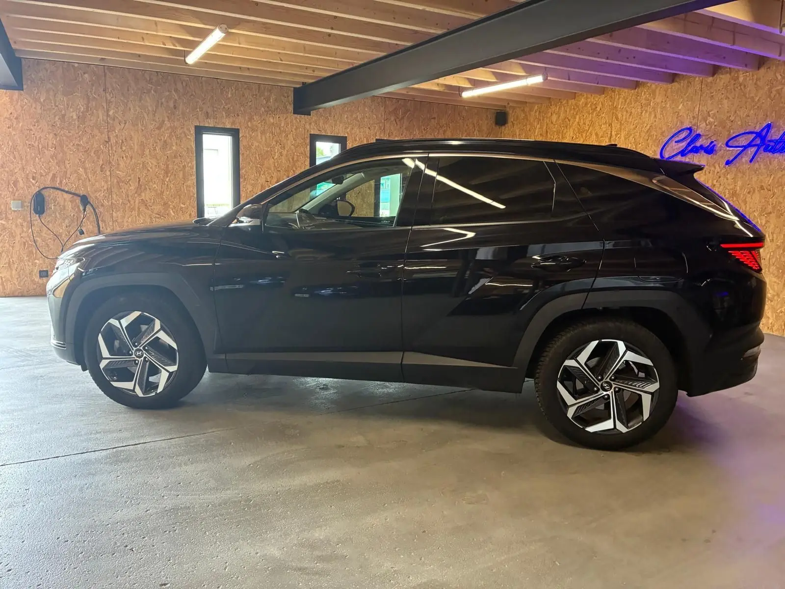 Vue de profil côté gauche du Hyundai Tucson noir 2022, mettant en valeur ses jantes modernes et sa silhouette compacte.