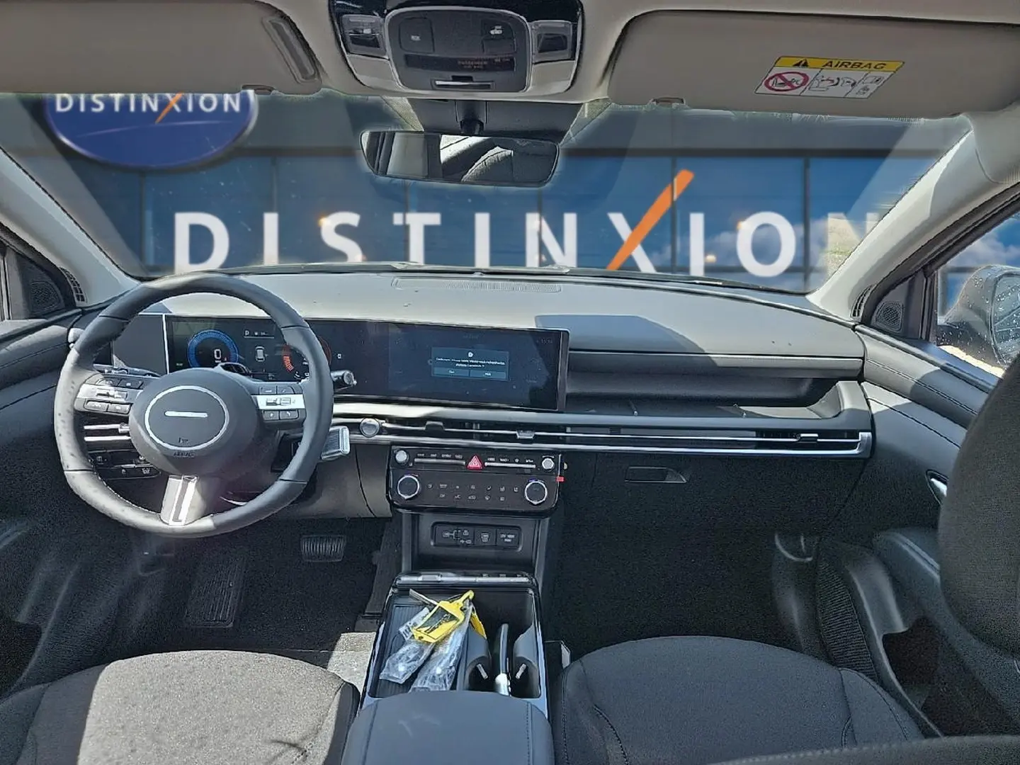 Vue intérieure avant du Hyundai Tucson 2026 noir, tableau de bord moderne avec écran tactile et volant multifonction.