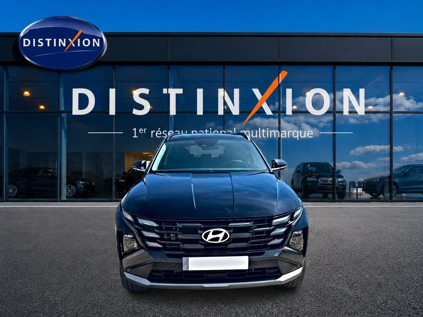 Vue de face du Hyundai Tucson noir 2026 avec calandre distinctive et logo Hyundai visible devant un showroom Distinxion.