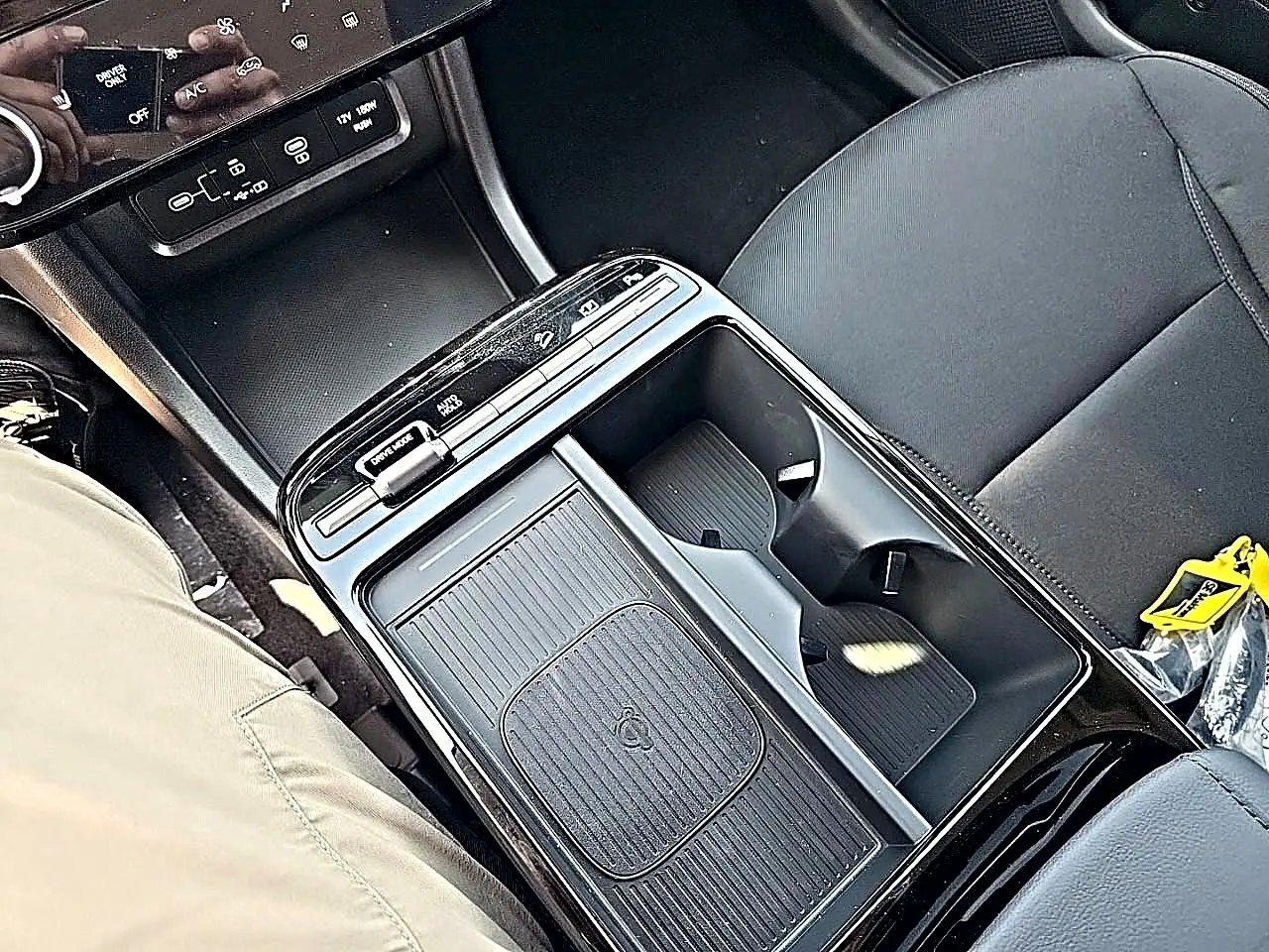 Vue plongeante sur la console centrale noire du Hyundai Tucson 2026, avec porte-gobelets et commandes tactiles.