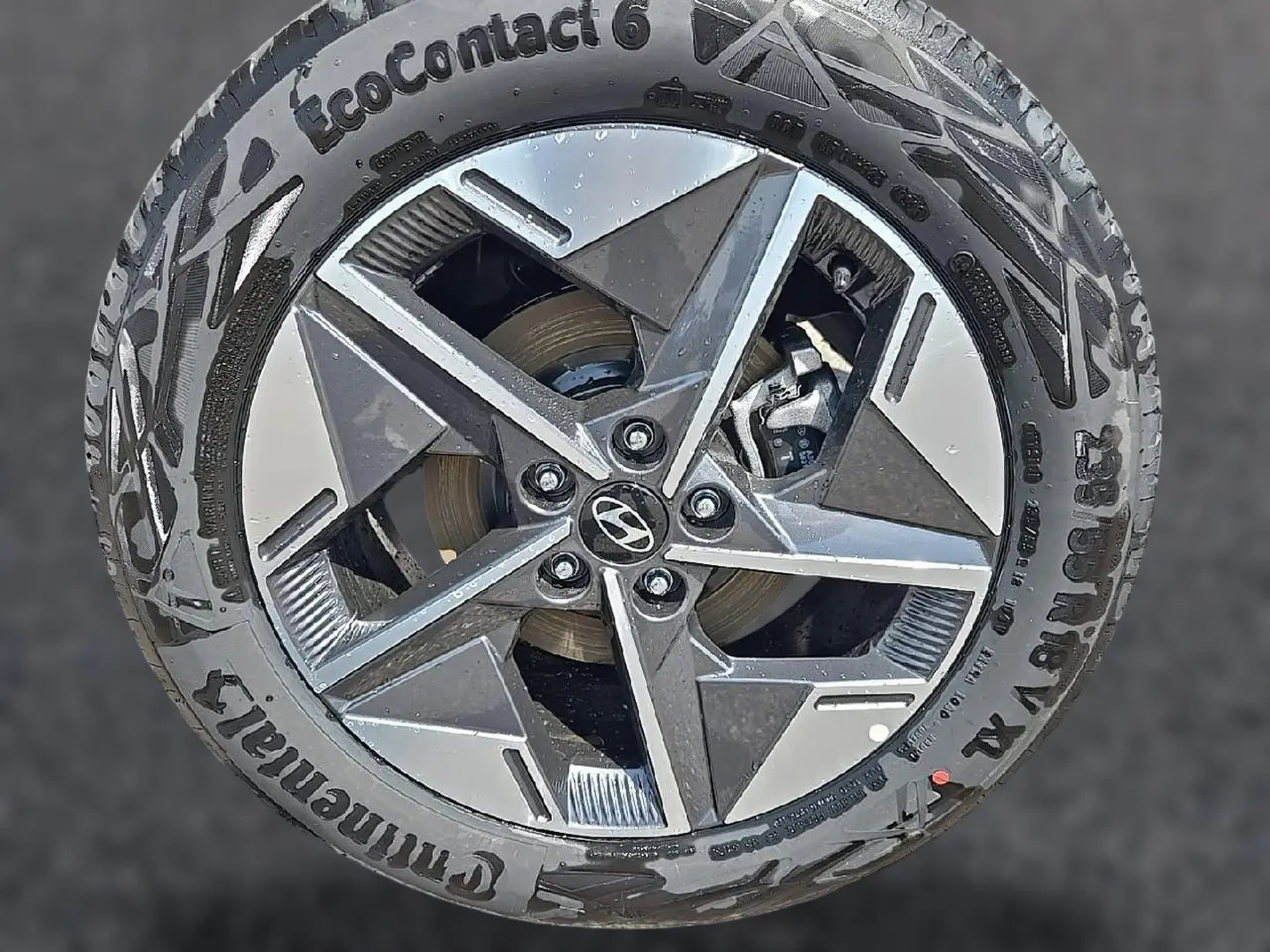 Gros plan sur une jante alu 18 pouces bicolore avec logo Hyundai au centre, montée sur pneu Continental EcoContact 6.