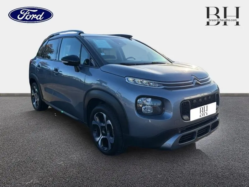 Citroën C3 Aircross gris acier vue 3/4 avant droit avec barres de toit et jantes diamantées 17 pouces.