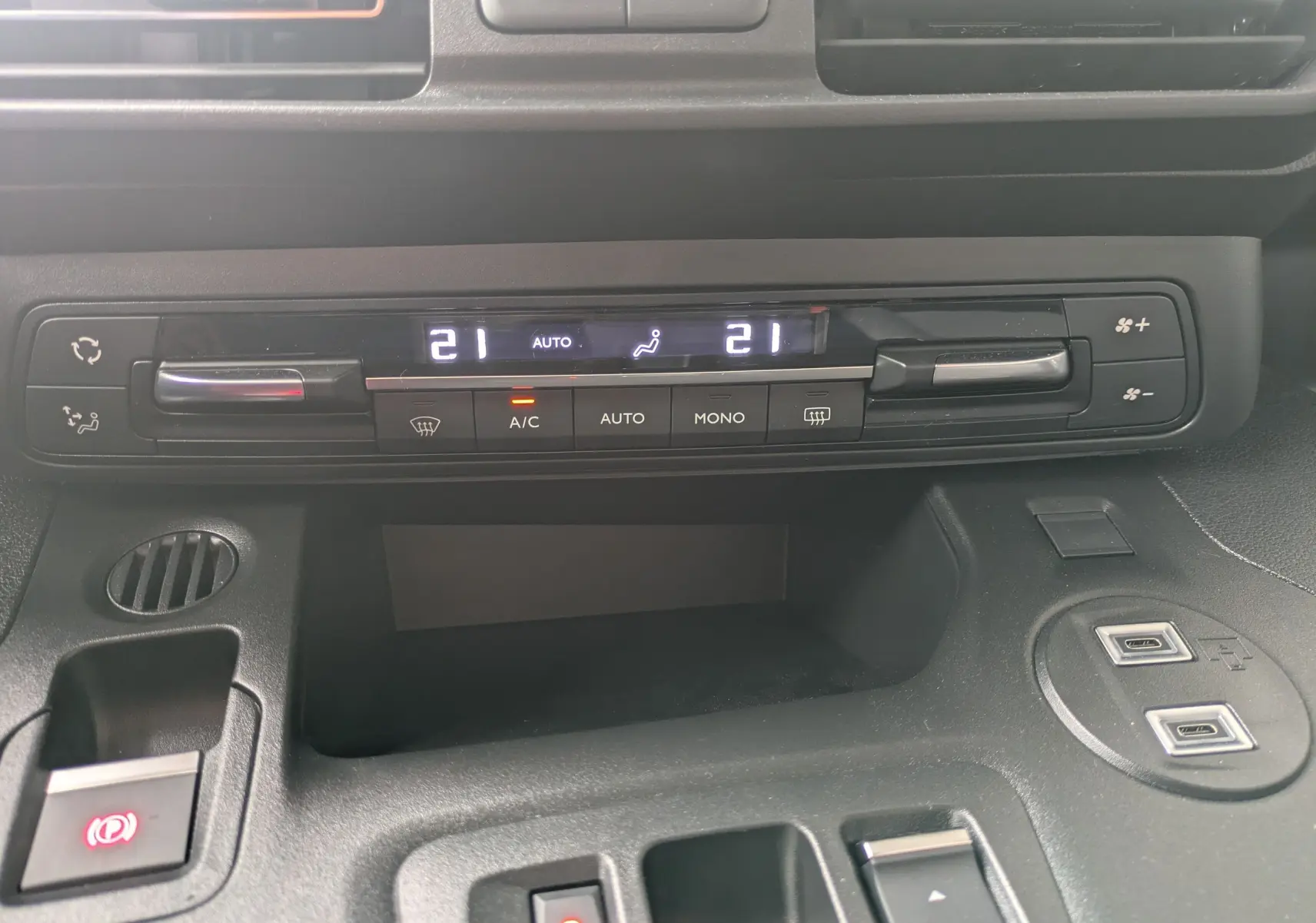 Détail du tableau de bord du Citroën Berlingo blanc 2025 montrant la climatisation automatique à 21°C et commandes USB.