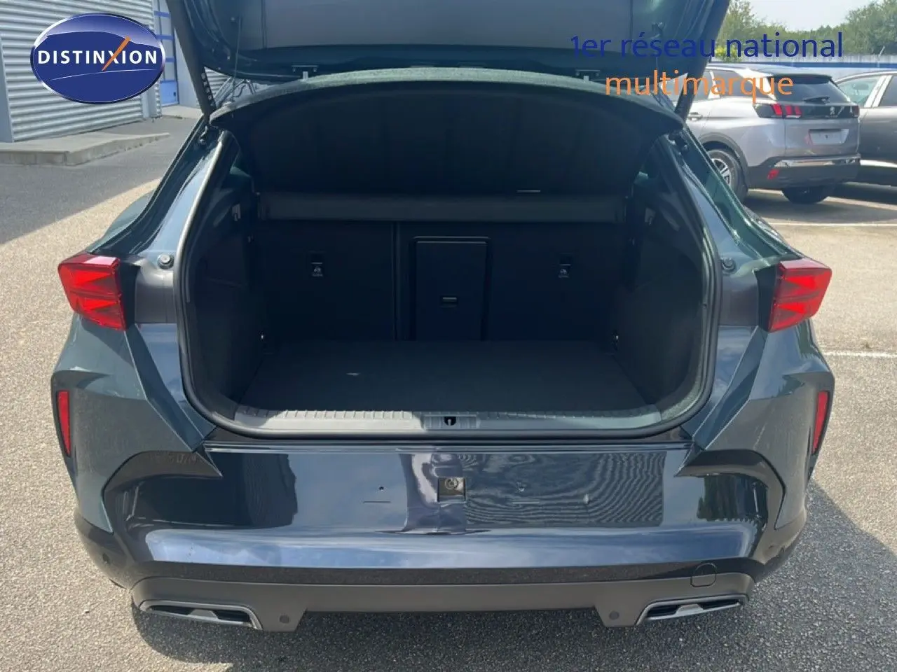 Vue arrière du CUPRA Formentor bleu Fjord Metal 2026 avec coffre ouvert et hayon relevé, montrant l'espace de chargement.
