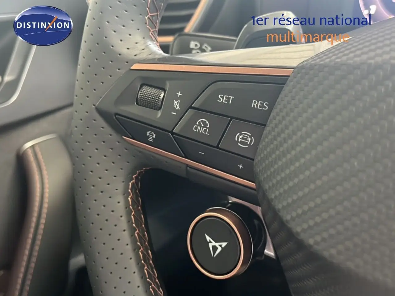 Gros plan sur le volant perforé noir de la CUPRA Formentor 1.5 eTSI avec commandes intégrées et finition cuivre.