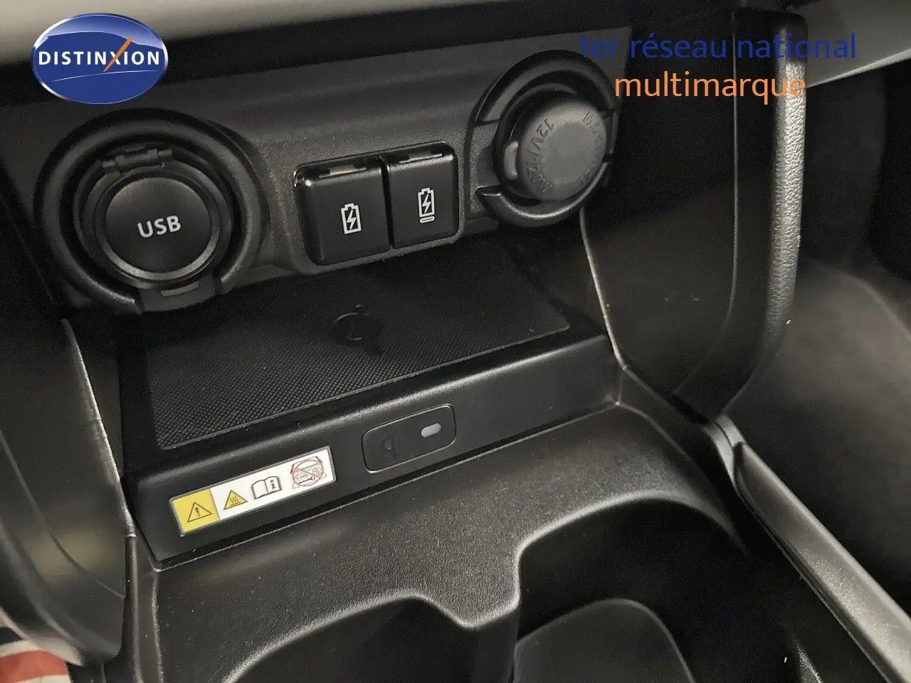 Gros plan sur la console centrale intérieure de la Suzuki Swift 1.2 Pack Hybrid 2024, montrant prises USB et ports de charge.