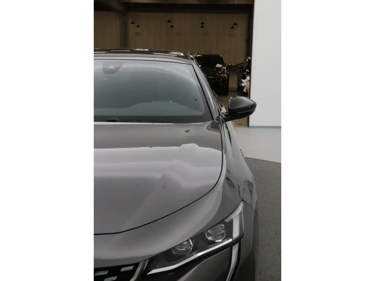 Vue avant droite d'une Peugeot 508 SW gris Platinium avec phares Full LED et rétroviseur noir brillant.