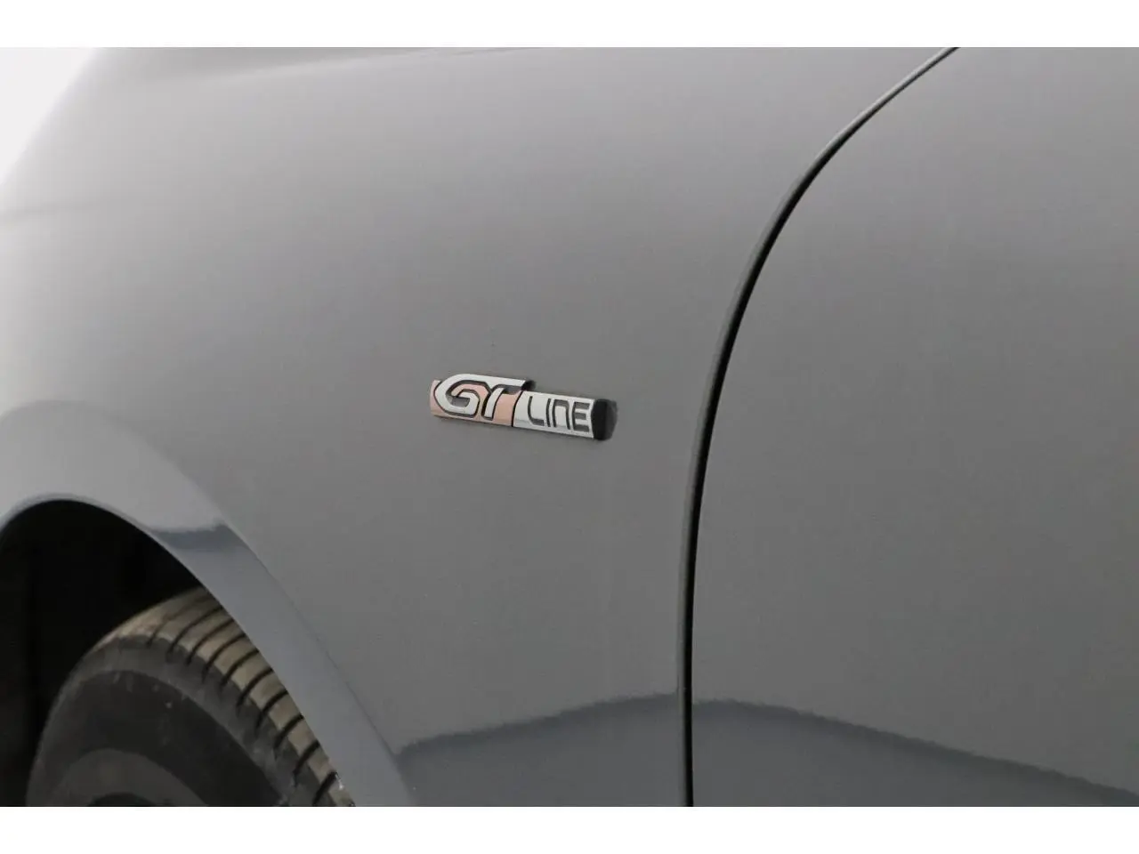 Gros plan sur l'aile avant gauche gris Platinium d'une Peugeot 508 SW avec badge GT Line visible.