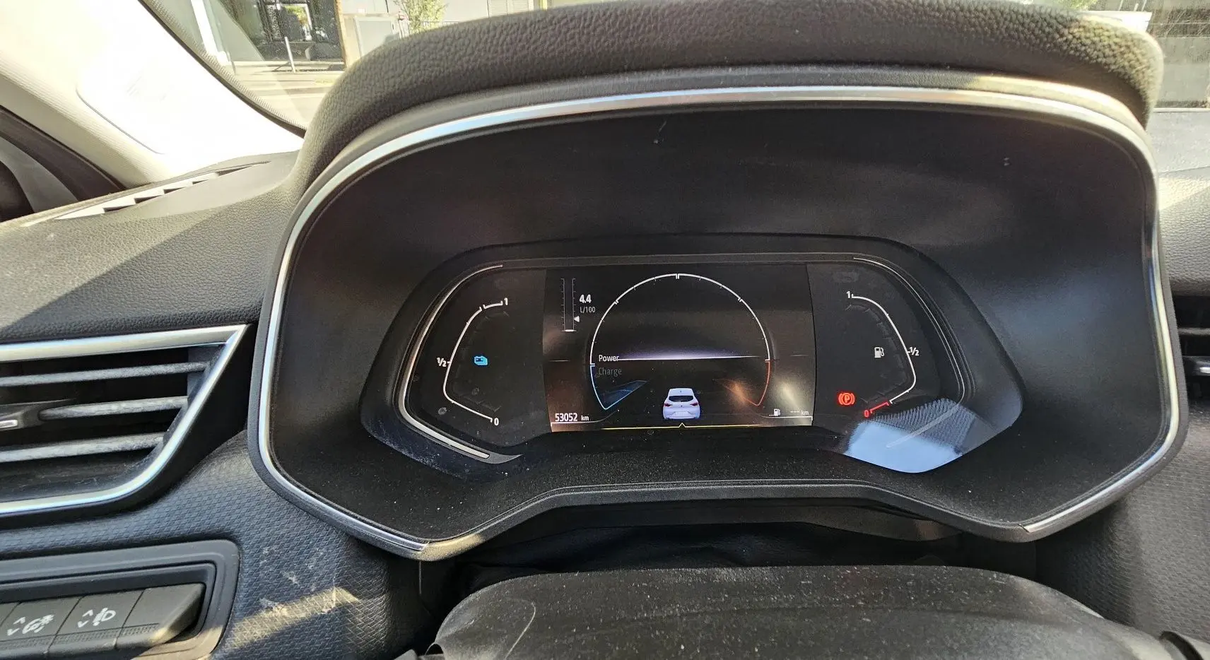 Tableau de bord numérique de la Renault Clio hybride 2021, affichant consommation et autonomie, intérieur noir.