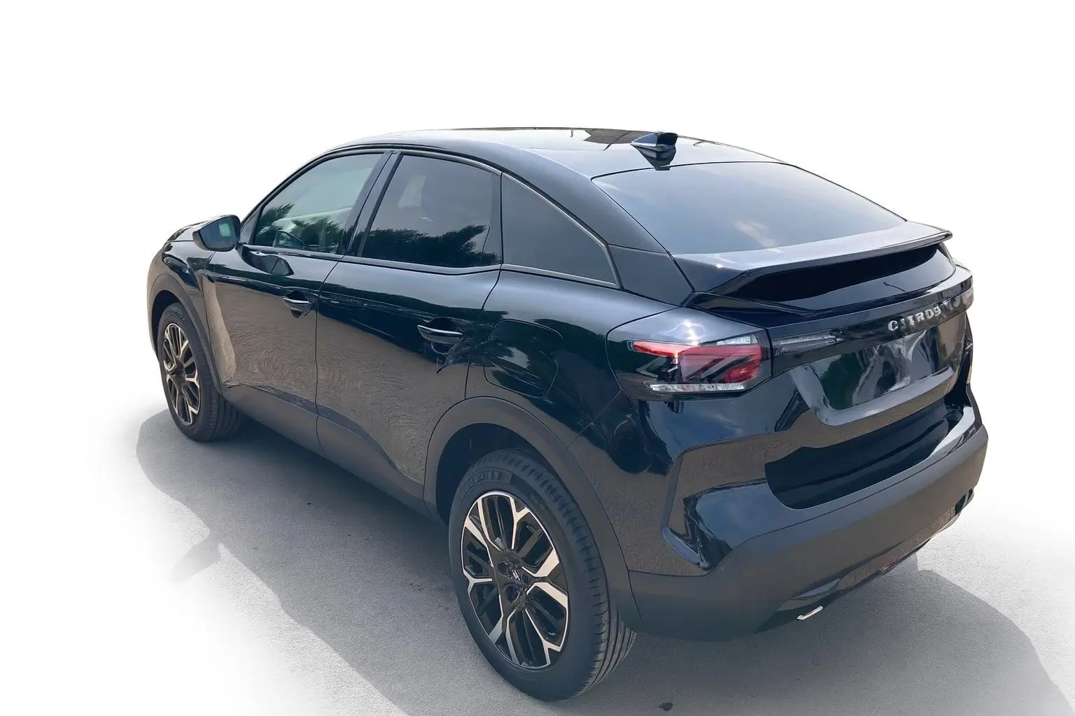 Vue 3/4 arrière droite d'une Citroën C4 noire Perla avec jantes alliage 18 pouces et vitres surteintées.