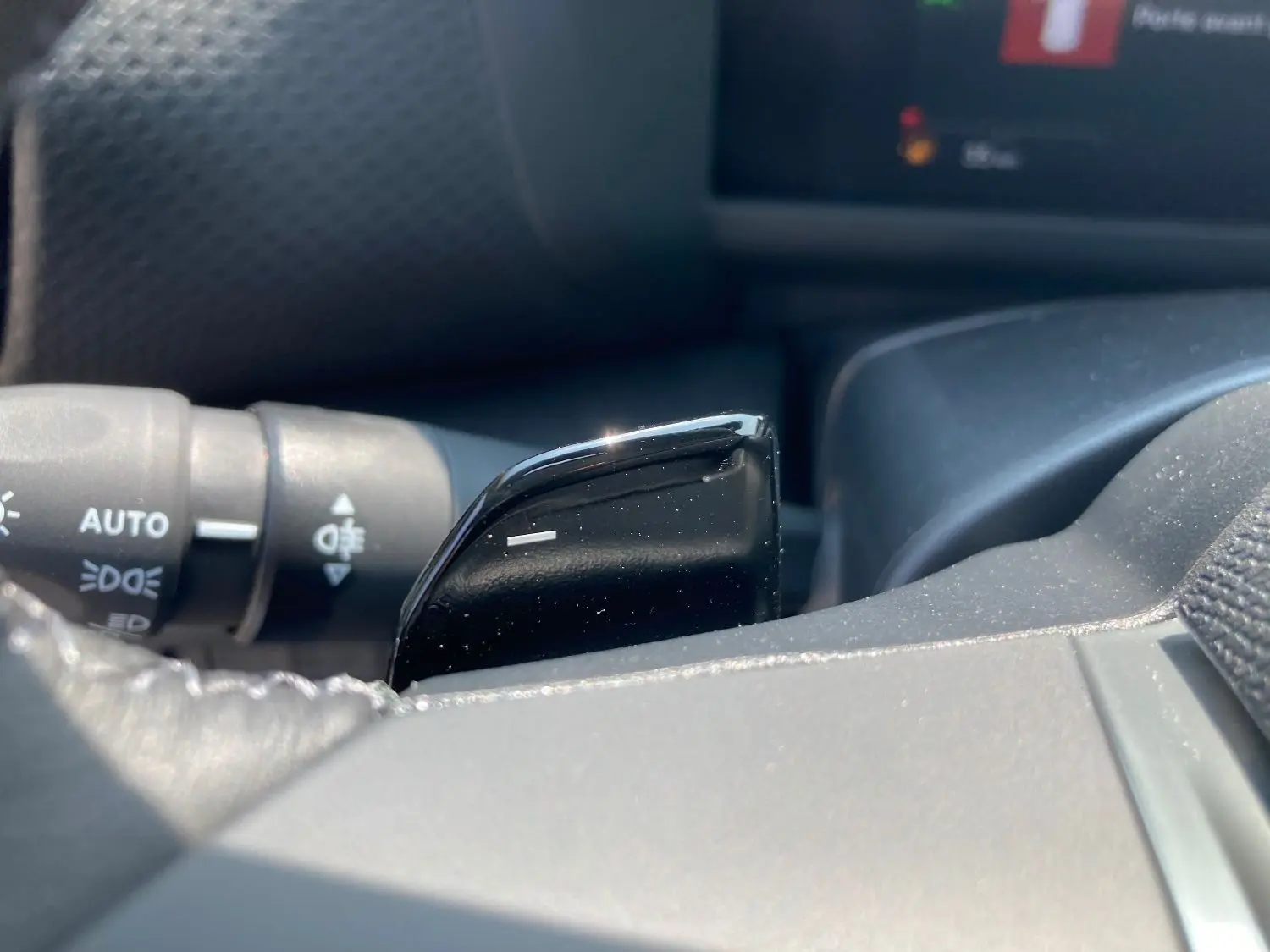 Gros plan sur la palette de changement de vitesse noire côté droit du volant d'une Citroën C4 hybride 2025.