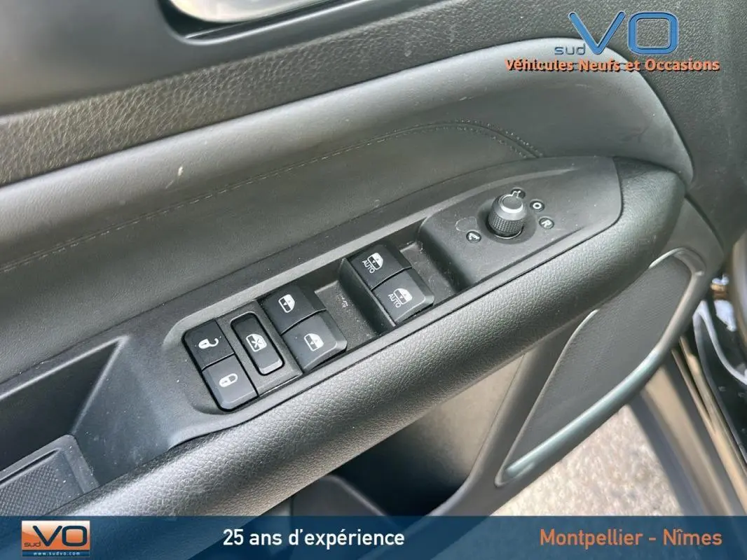 Gros plan sur les commandes de vitres et rétroviseurs sur la porte côté conducteur du Jeep Compass noir 2024.