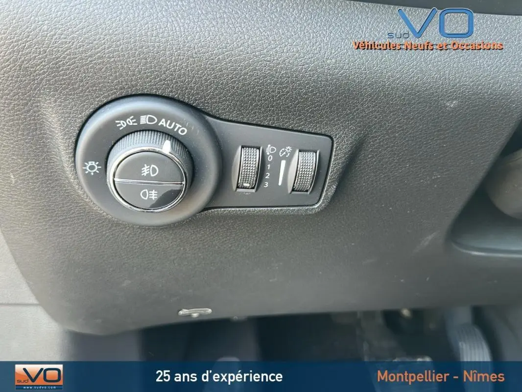 Gros plan sur le bouton de commande des phares du Jeep Compass noir 2024, montrant les réglages d'éclairage automatique.