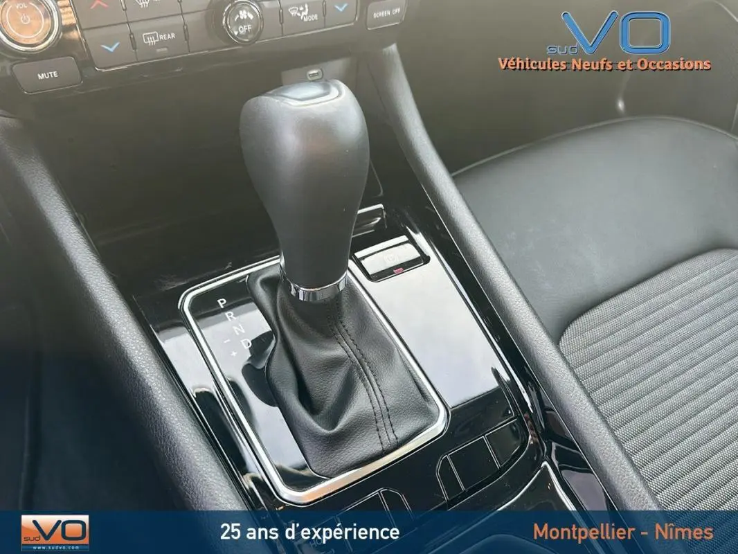 Gros plan sur la console centrale et levier de vitesse automatique du Jeep Compass noir 2024 avec sellerie sombre.