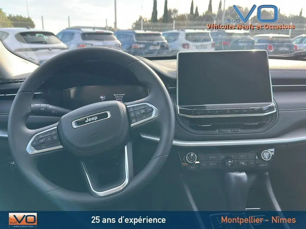 Vue intérieure du tableau de bord et volant noir du Jeep Compass 2024 avec écran tactile et commandes au volant visibles.