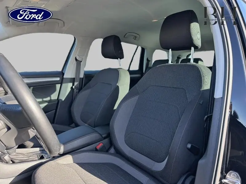 Vue intérieure côté gauche du Skoda Kodiaq noir Magic Nacré 2023, mettant en valeur les sièges avant en tissu noir et gris.