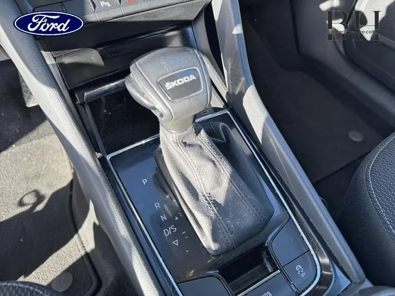 Le levier de vitesses automatique noir marqué SKODA dans l'habitacle du KODIAQ 2023 vu en plongée.