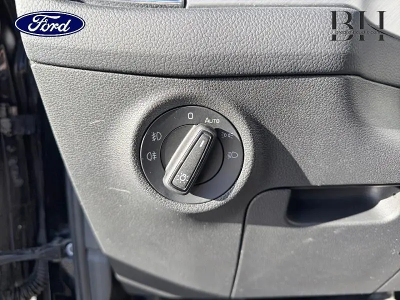 Gros plan sur la molette de réglage des phares sur la gauche du tableau de bord d'un Skoda Kodiaq noir Magic Nacré 2023.