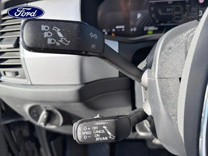 Gros plan sur les commandes au volant d'un Skoda Kodiaq noir Magic Nacré, montrant les leviers de clignotants et régulateur de vitesse.