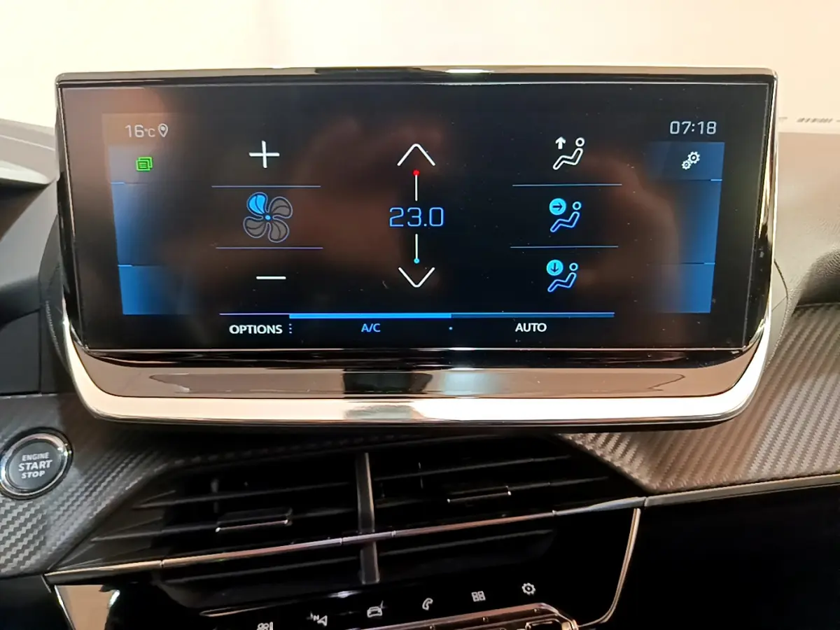 Écran tactile central affichant la climatisation à 23°C sur le tableau de bord carbone du Peugeot 2008 gris clair.