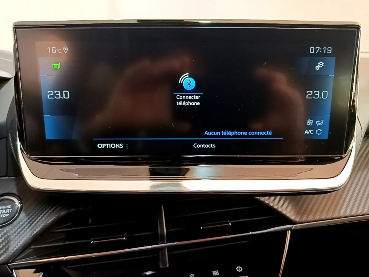 Écran tactile central du tableau de bord de la Peugeot 2008 gris clair, affichant la connexion Bluetooth et la climatisation à 23°C.