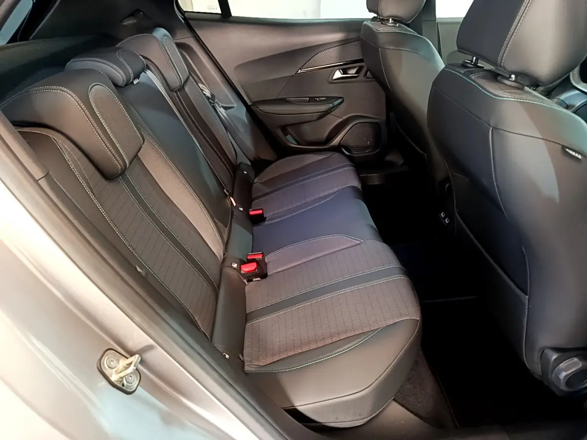 Vue latérale intérieure des sièges arrière gris foncé du Peugeot 2008 PureTech 130, avec appuie-têtes et ceintures visibles.