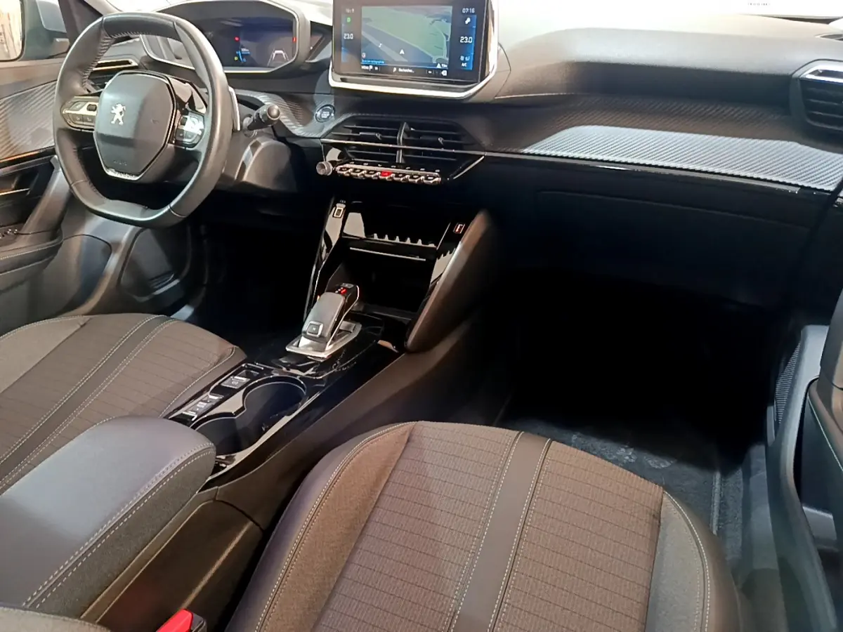 Intérieur avant du Peugeot 2008 gris clair, vue côté conducteur, avec tableau de bord numérique et écran tactile central.