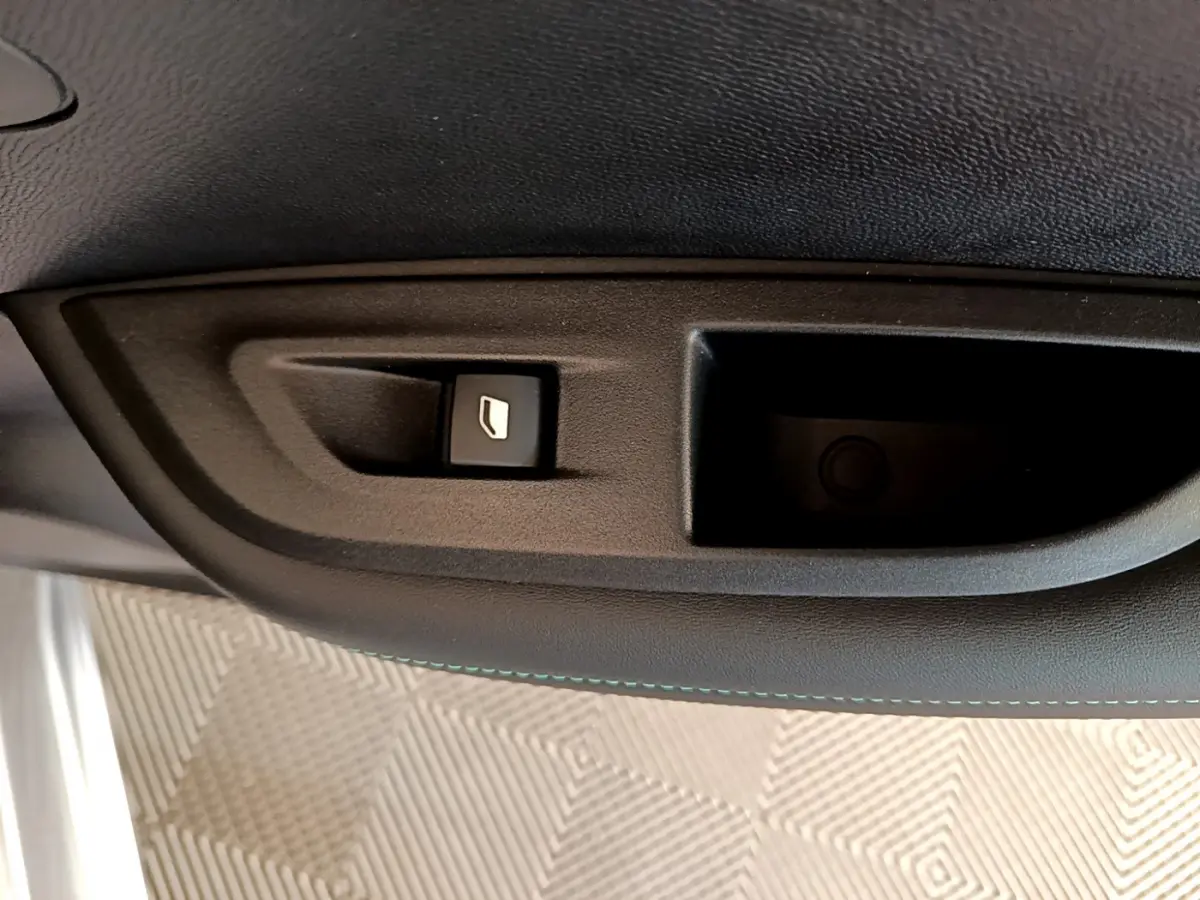 Bouton de commande de lève-vitre sur la porte intérieure, tissu noir, Peugeot 2008 gris clair 2021.