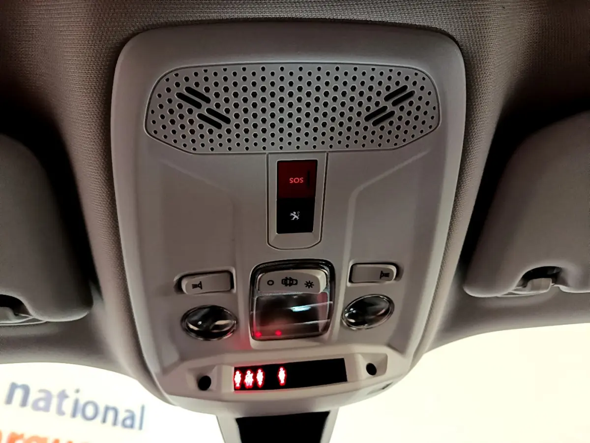 Plafonnier intérieur avec boutons SOS et éclairage, vue en contre-plongée dans un Peugeot 2008 gris clair de 2021.