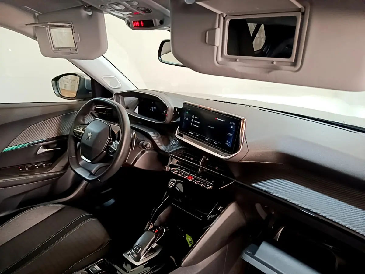 Intérieur Peugeot 2008 gris clair vu côté conducteur, tableau de bord avec écran tactile et volant cuir multifonctions.