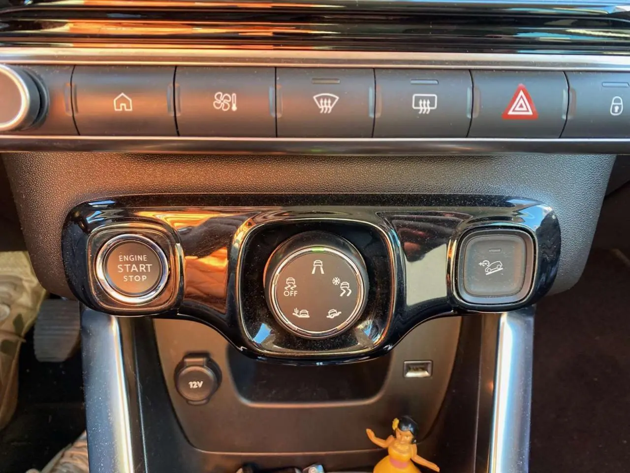 Gros plan sur la console centrale du Citroën C3 Aircross gris foncé 2024, avec boutons de démarrage et contrôle Grip Control.
