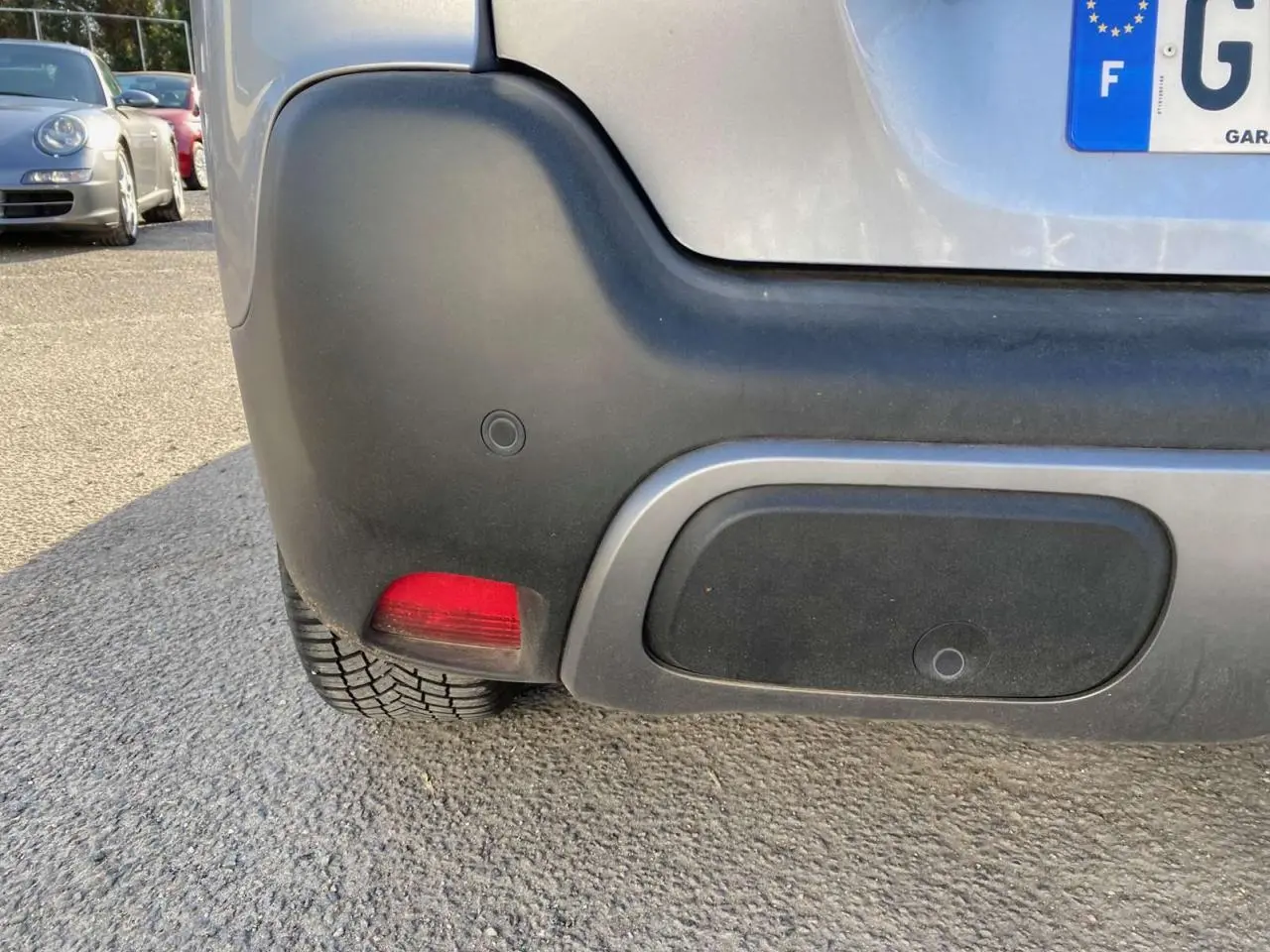 Gros plan sur le coin arrière gauche du Citroën C3 Aircross gris foncé 2024, avec feu rouge et pare-chocs noir.