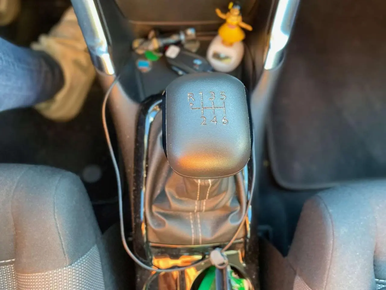 Gros plan sur le levier de vitesses manuel noir de la Citroën C3 Aircross gris foncé, avec console centrale et sièges partiellement visibles.