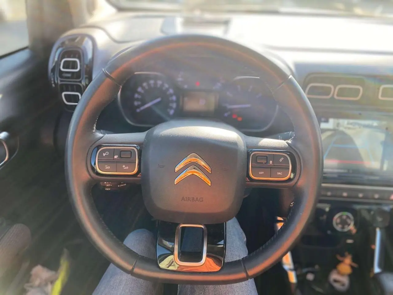 Vue intérieure centrée sur le volant du Citroën C3 Aircross 2024, avec commandes intégrées et tableau de bord visible.