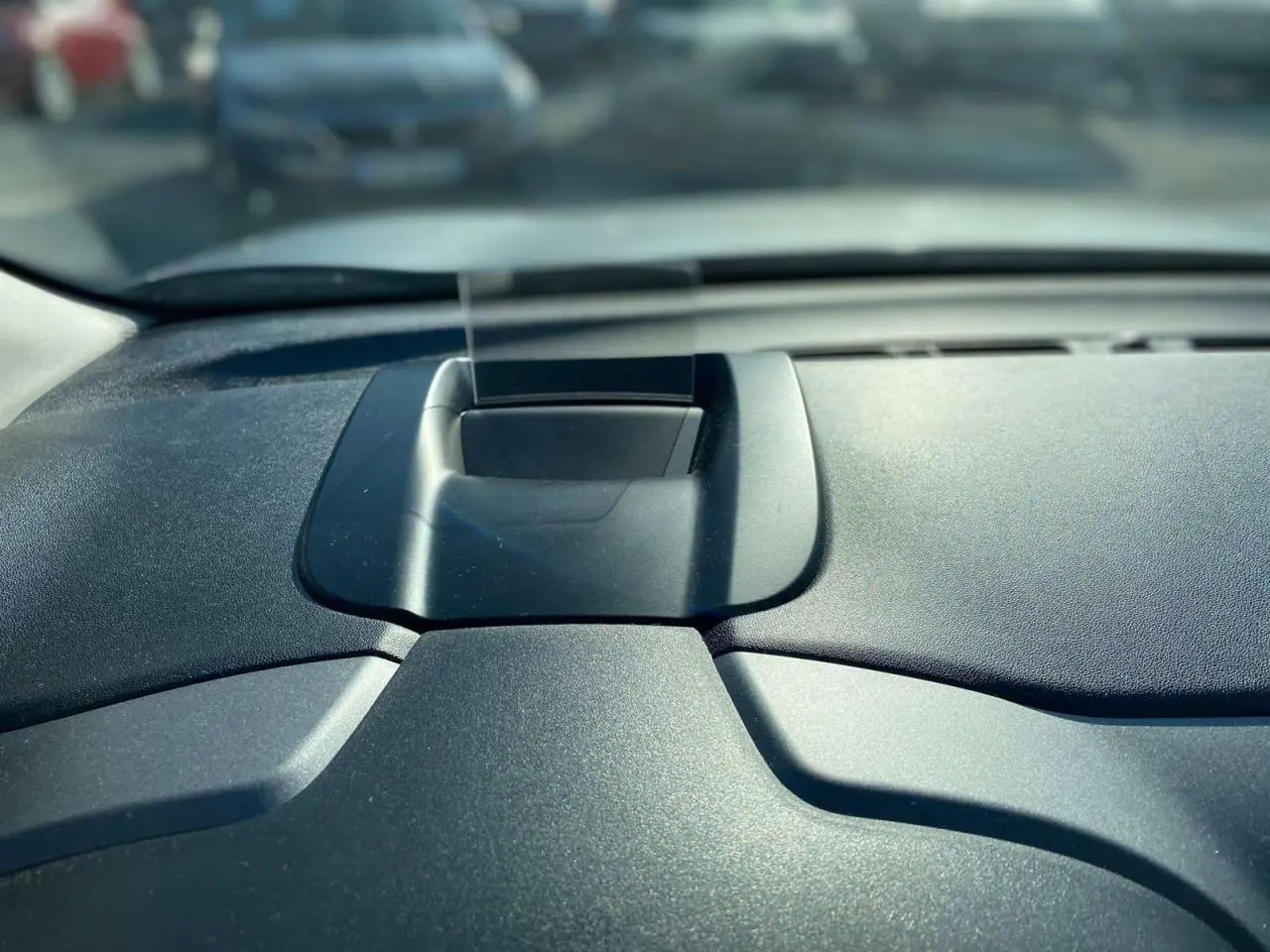 Détail du tableau de bord noir du Citroën C3 Aircross 2024 avec écran escamotable au centre, vue intérieure frontale.