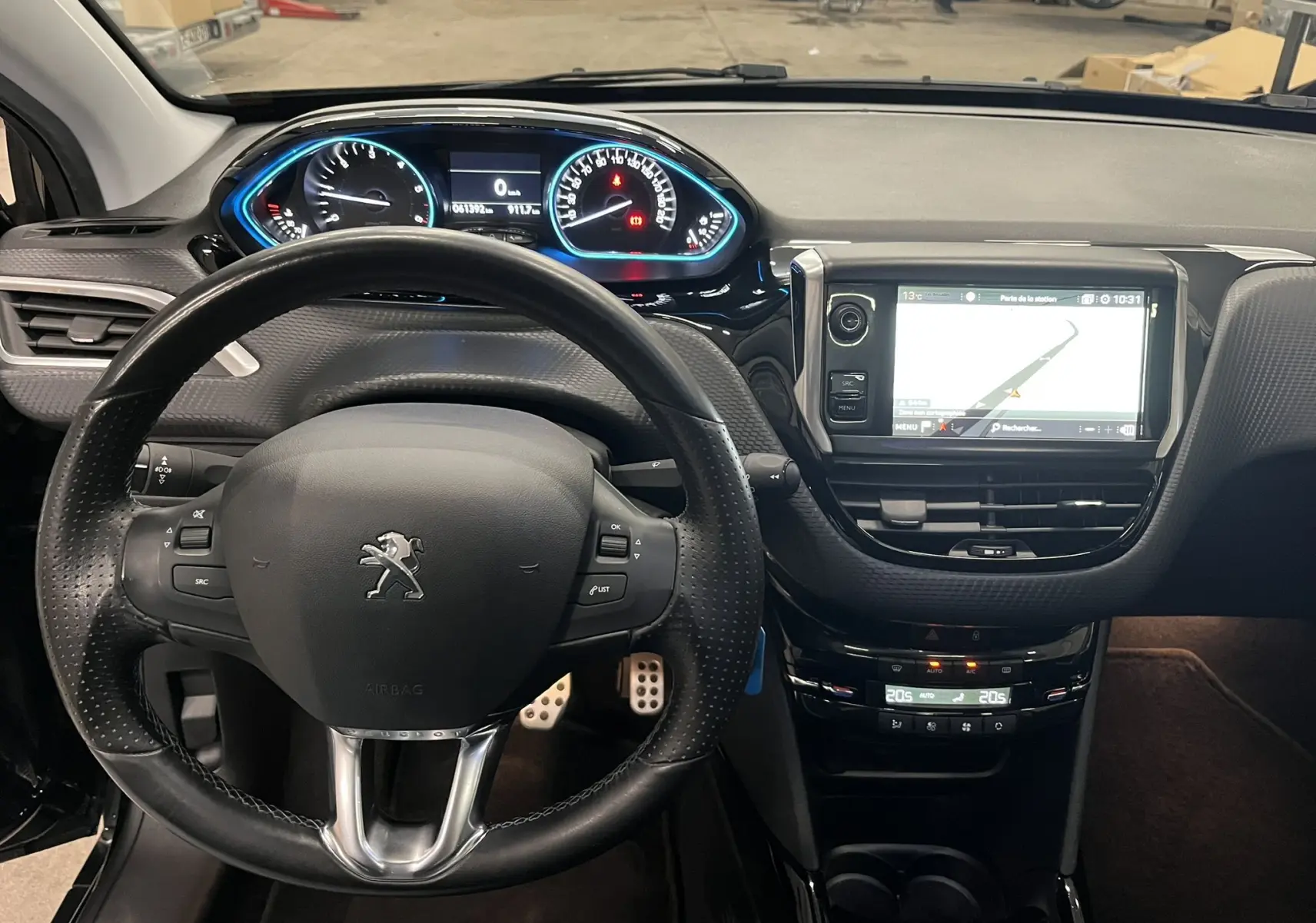 Vue intérieure du tableau de bord et volant noir de la Peugeot 2008 Crossway, avec écran tactile et compteurs lumineux bleus.