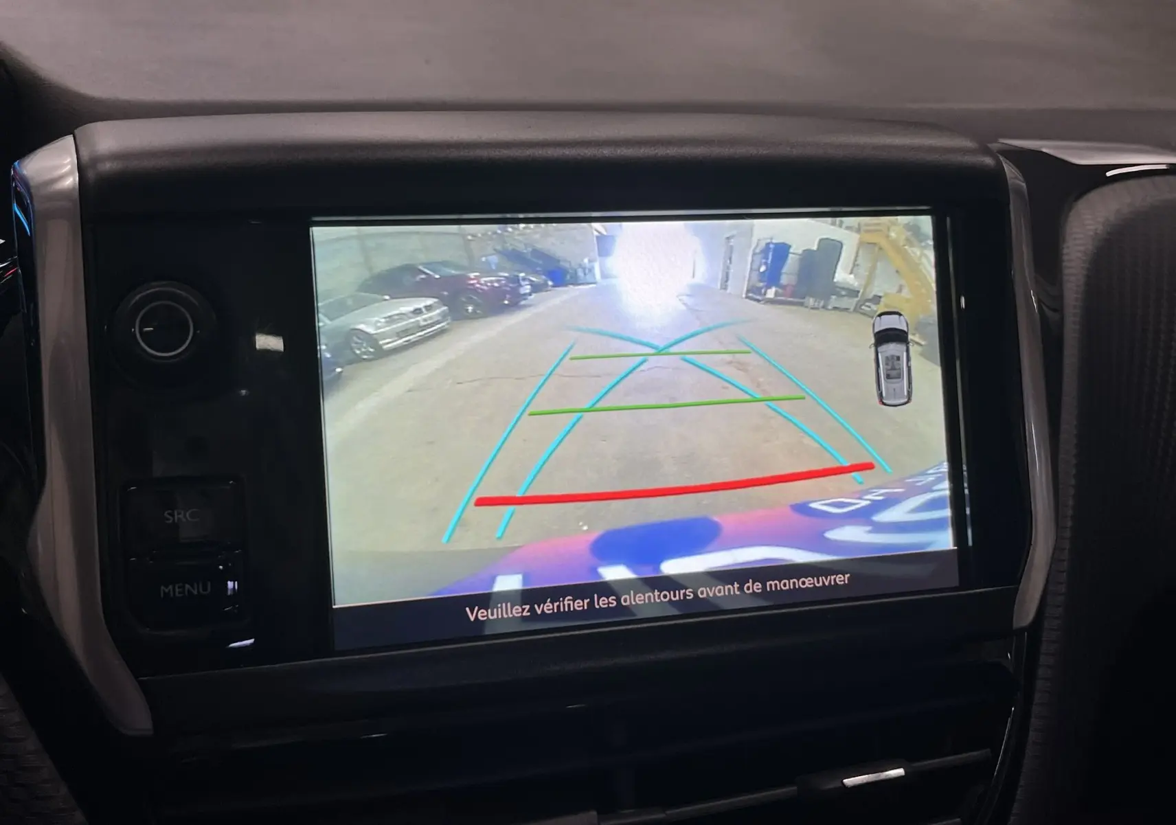 Écran central montrant la caméra de recul d’un Peugeot 2008 noir, vue arrière avec lignes d’aide au stationnement.