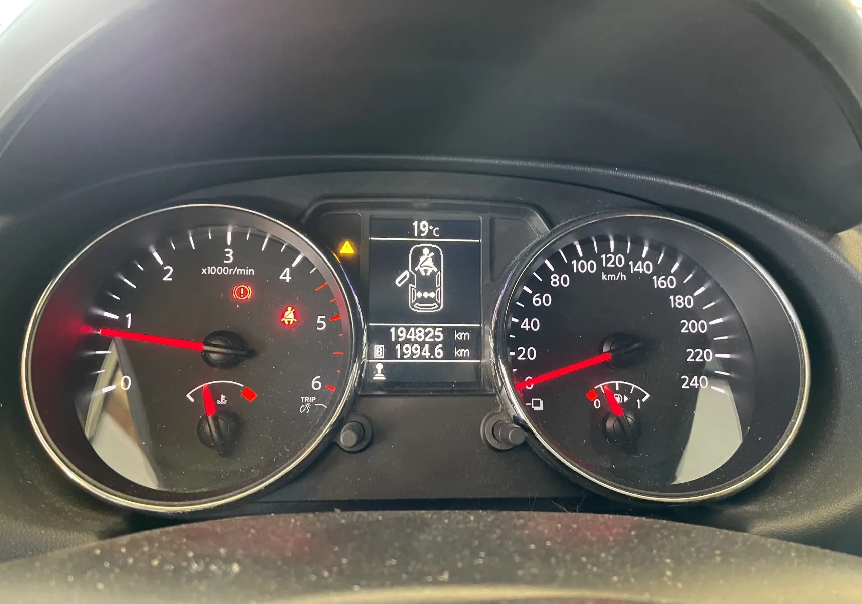 Tableau de bord du Nissan Qashqai blanc 2013, affichant compte-tours, vitesse, température et kilométrage.