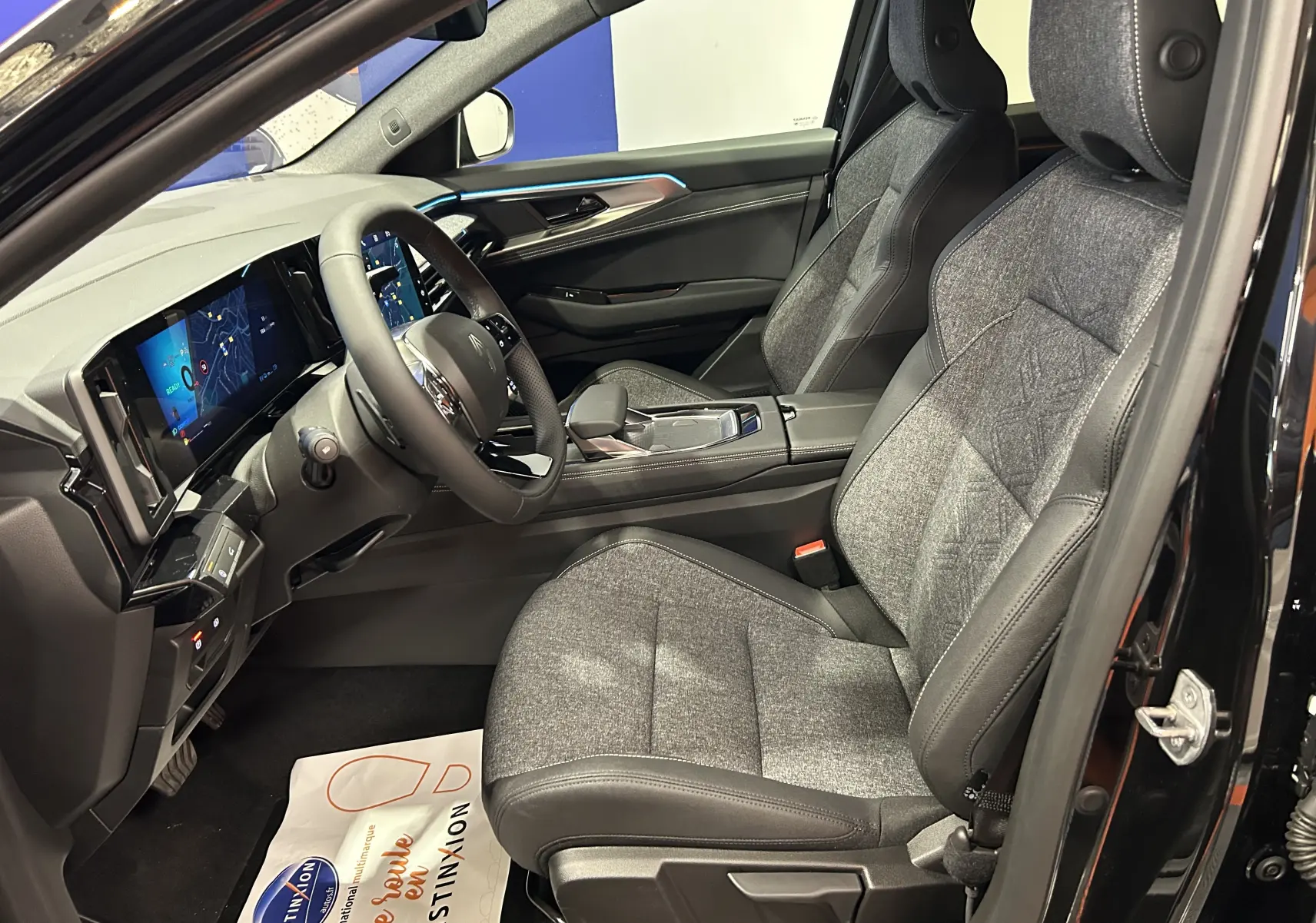 Intérieur côté conducteur du Renault Austral Ph.2 noir étoilé, sièges tissu et cuir gris avec tableau de bord digital moderne.