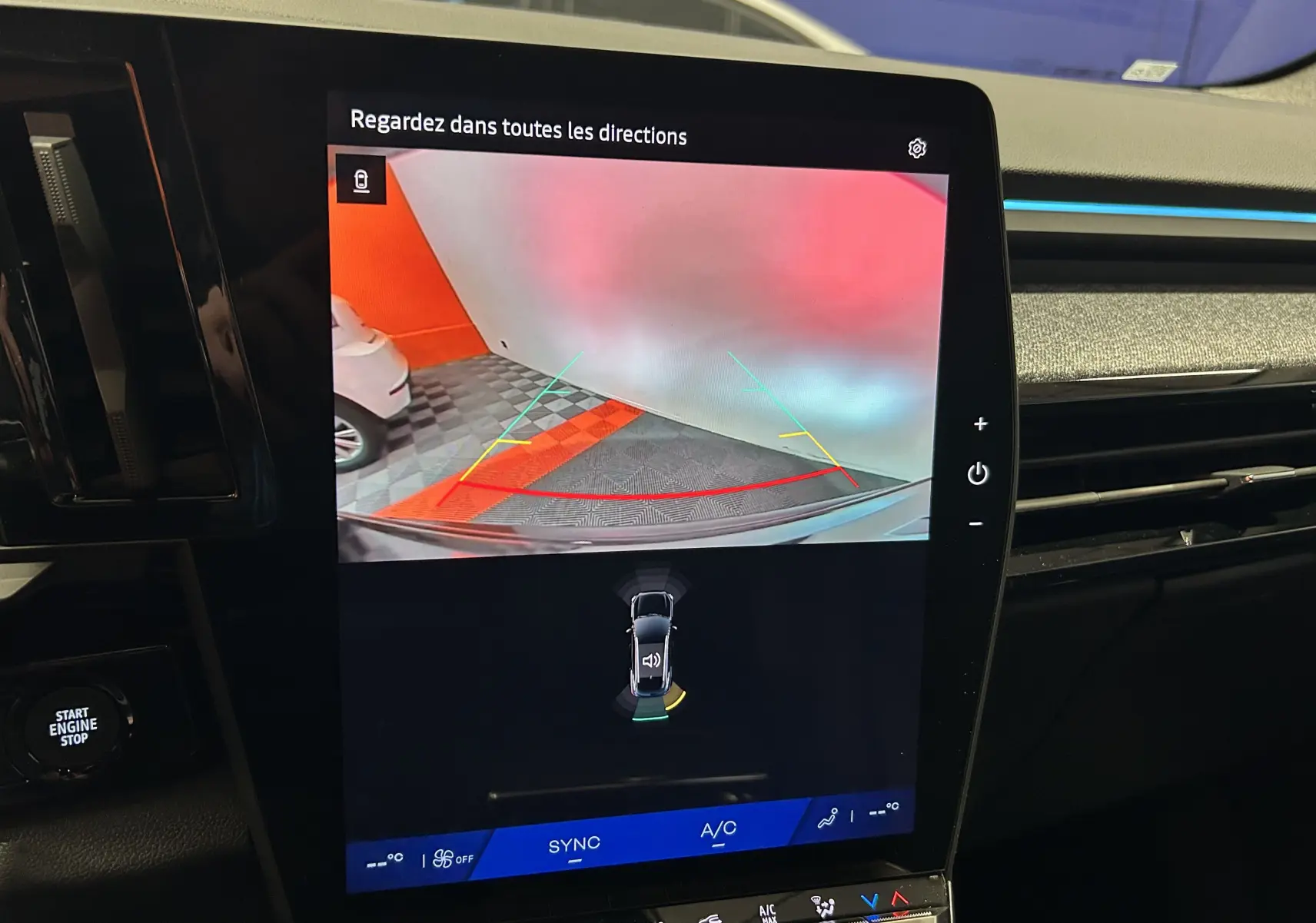 Écran central du Renault Austral Ph.2 E-TECH affichant la caméra de recul avec lignes de guidage colorées dans un parking.