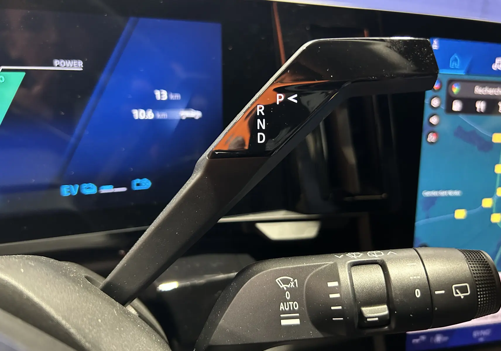 Le levier de vitesses automatique en gros plan dans l'habitacle du Renault Austral noir étoilé, avec affichage digital en arrière-plan.